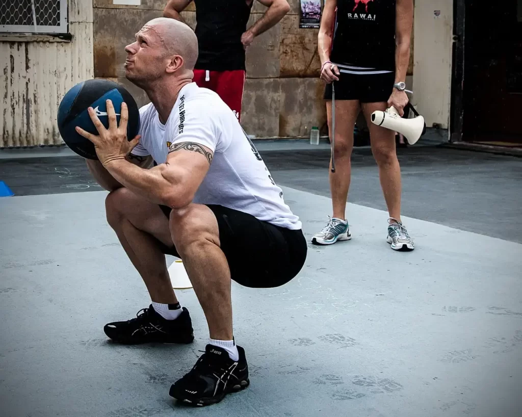 Crossfit atlet kastar boll mot vägg.